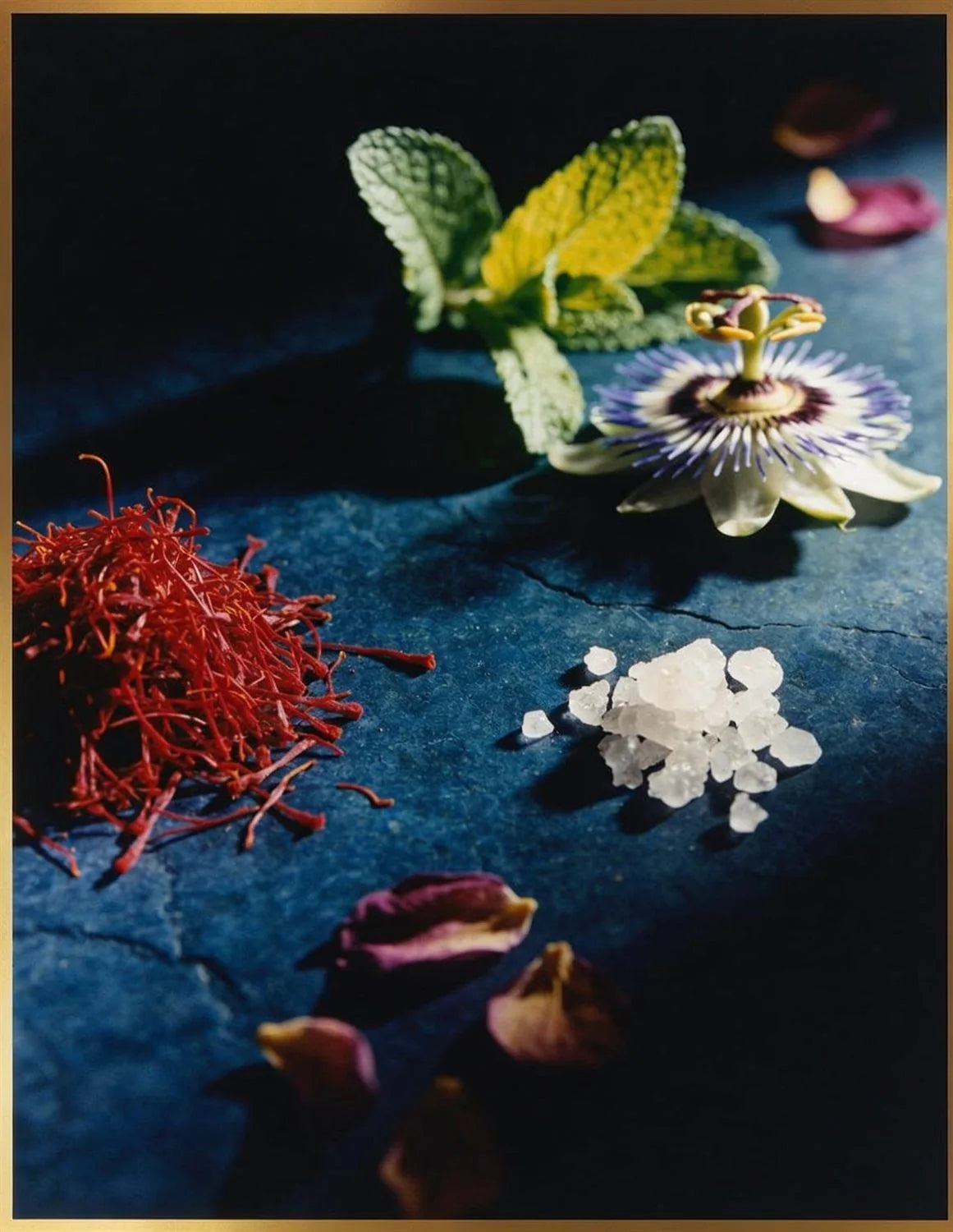 Saffron threads, lemon balm, passionflower and magnesium crystals on indigo stone